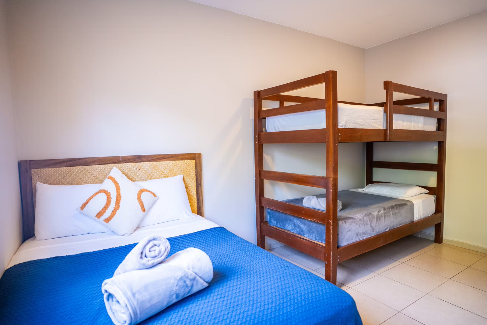 Full bed beside the wooden bunk bed in bedroom three