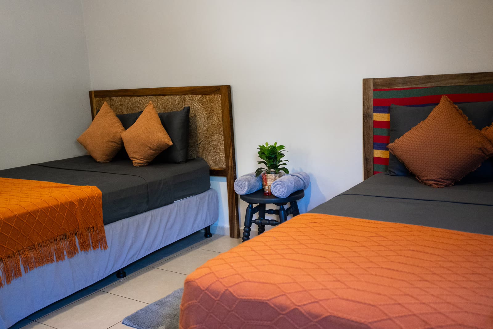 Two full beds with warm orange bedding in bedroom four